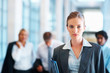 Happy business woman with colleagues at the background