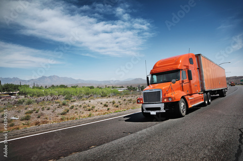 Photo: Orange American truck on freeway Orange American truck on freeway
