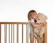 portrait of little girl keeping teddybears in crib