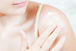 Woman applying cream on her shoulder Woman applying cream on her shoulder