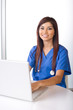 Female nurse at a desk working in a modern office Female nurse at a desk working in a modern office