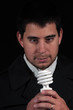 male portrait staring at new light bulb isolated on black male portrait staring at new light bulb isolated on black