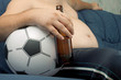 Men sitting on the sofa with a bottle of beer.