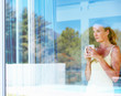 Woman at her window having tea, contemplating