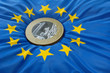 Euromünze auf Europaflagge