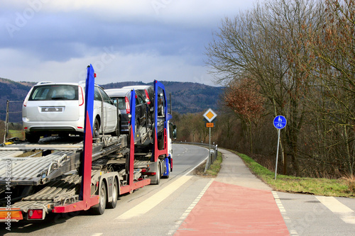 Foto: Autotransporter bei der Fahrt über eine Landstrasse Autotransporter bei der Fahrt über eine Landstrasse