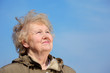 Smiling aged woman look in sky