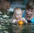 mother teaching her baby girl to swim