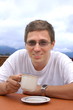 Man drinking coffee over blue sky background