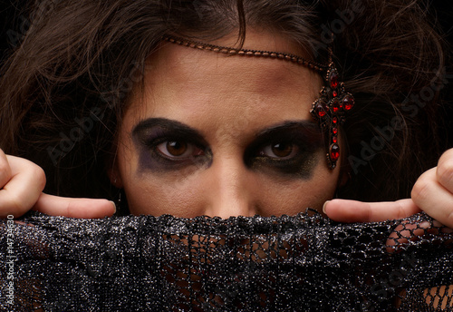 Photo: Portrait of witch over dark background Portrait of witch over dark background