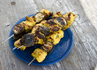 grilled chicken tikka with banana and mint on metal skewer