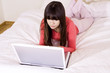Woman using a laptop in the bedroom