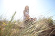 jeune femme assise en tailleur dans la nature