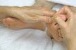 Close-up of reflexologist working on woman's big toe