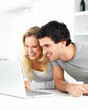 Happy young man and young woman using a laptop together