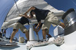 Sailors operating windlass on yacht, low angle view