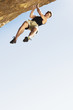 Climber Jumping off Cliff, low angle view