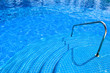 Pool with blue water stairs rail at daylight