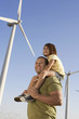 Father and daughter 5-6 on wind farm, side view