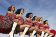 Cheerleaders in a row kicking legs