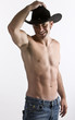 Foto: An attractive cowboy with his shirt off in studio An attractive cowboy with his shirt off in studio