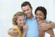 Young man with arms round two female friends, portrait
