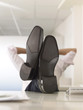 Businessman with Feet Up on Desk, obscured face
