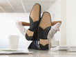 Businessman with Feet Up on Desk, obscured face