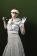 Woman in visor holding golf club behind shoulders, portrait