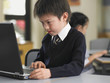 Elementary student using laptop in classroom