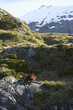 Two hikers sitting on boulders in mountain valley