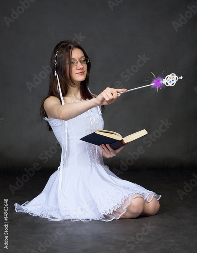 Photo: Girl - sorcerer with the book and a magic wand Girl - sorcerer with the book and a magic wand