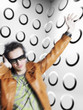 Photo: Man wearing headphones and sunglasses, blurred motion, in front of spotty wall Man wearing headphones and sunglasses, blurred motion, in front of spotty wall