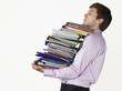 Male office worker carrying heavy binders, on white background