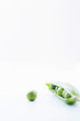 Open pea pod containing peas and single pea, close-up