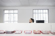 Photo: Female office worker using telephone, smiling, in office cubicle behind trays with documents Female office worker using telephone, smiling, in office cubicle behind trays with documents
