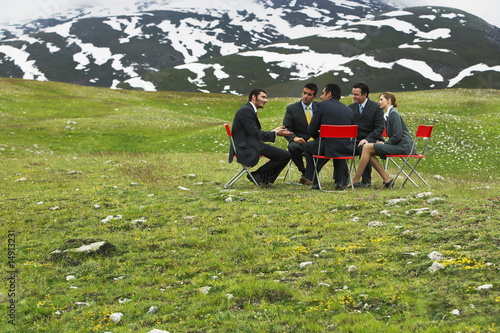 Photo: Business People having conference in mountain field Business People having conference in mountain field