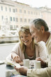 Photo: Middle-aged couple at outdoor cafe in Rome looking at map, head and shoulders Middle-aged couple at outdoor cafe in Rome looking at map, head and shoulders