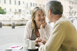 Middle-aged couple sitting at outdoor cafe in Rome, close up