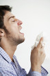 Man about to sneeze into facial tissue