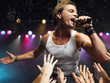 Young Man Singing on stage in concert close to adoring fans, low angle view