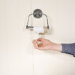 End of toilet roll with fingers picking last bit of paper