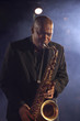 Jazz musician playing saxophone on smokey nightclub stage