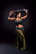 Attractive bellydancer in tribal costume and holding sword Attractive bellydancer in tribal costume and holding sword