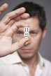 Man holding dice between finger and thumb, focus on foreground