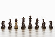 Single white pawn in initial line up of black chess pieces
