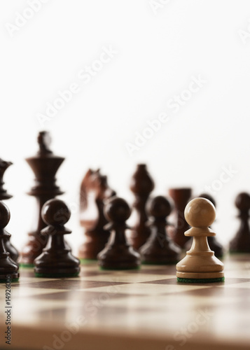 Photo: Chess game, one white piece in front of black pieces Chess game, one white piece in front of black pieces