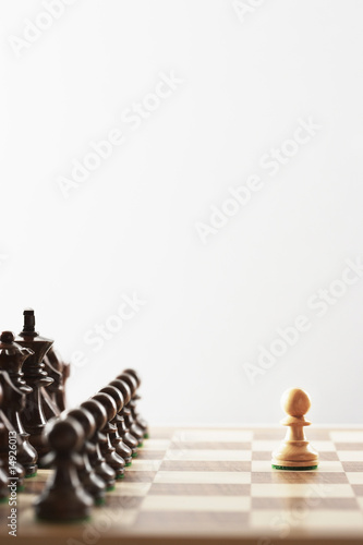 Photo: Chess game, single white piece in front of black pieces Chess game, single white piece in front of black pieces