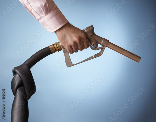 Foto: Man holding fuel pump with knot in pipe, close up of hand Man holding fuel pump with knot in pipe, close up of hand