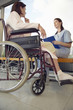 Nurse talking to patient in wheelchair, low angle view